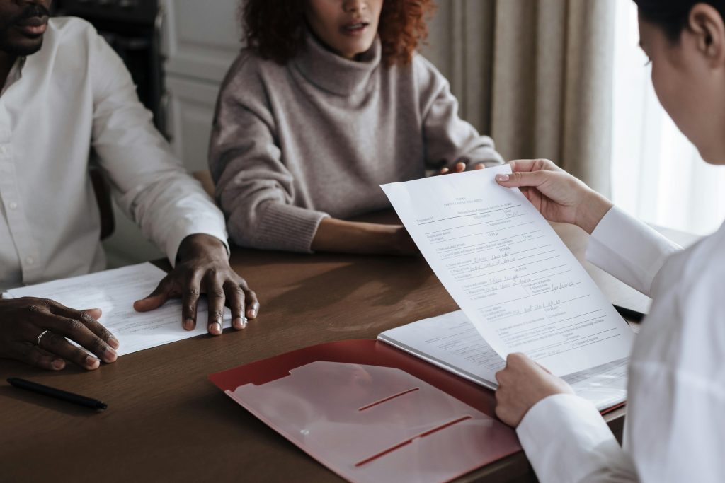 2 jobseekers with an Employment Advisor in an office setting.